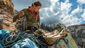 A young climber sorts through her climbing gear.&nbsp;
