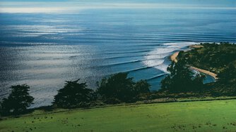 A swell of waves rolling into a point break.
